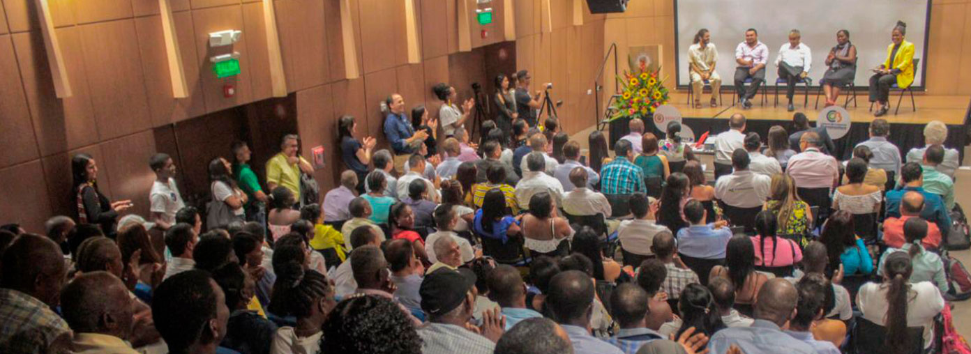 Grupo de personas asistentes a Evento de Buenaventura, de cara al escenario del auditorio.